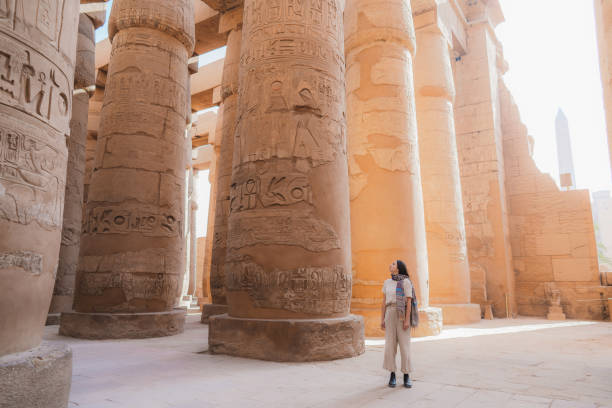 frau zu fuß in der alten ägyptischen tempel in luxor - ancient religion stock-fotos und bilder