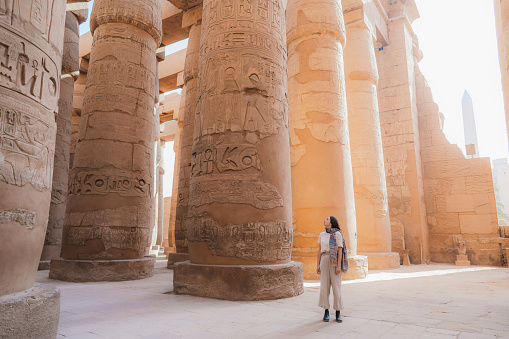 Young Caucasian woman walking in the ancient Egyptian temple in Luxor