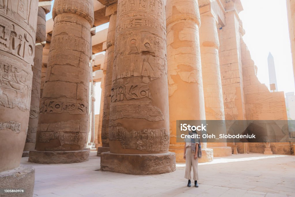 Woman walking in the ancient Egyptian temple in Luxor Young Caucasian woman walking in the ancient Egyptian temple in Luxor Egypt Stock Photo