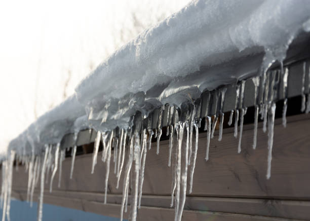 istock Roof cornice with icicles, snow, wooden house. Spring 1305841928