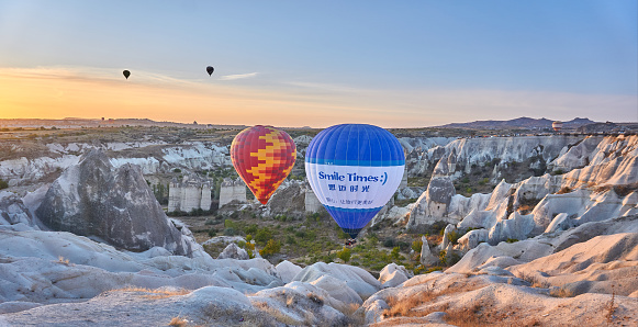 Göreme, Turkey - October  25, 2020: Colorful hot air balloons flying early in the morning over the valley at Cappadocia, Nevşehir, Turkey.