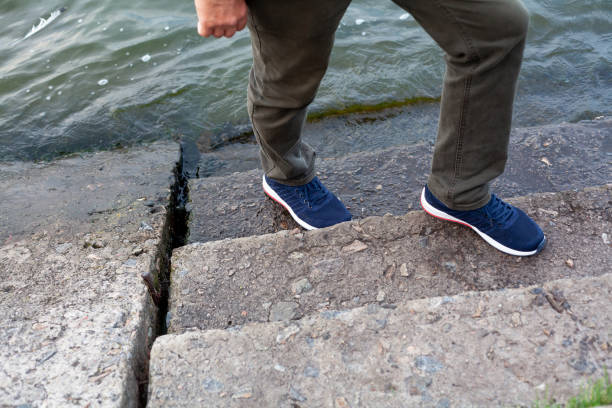 istock Feet in sneakers stand on steps above water 1305843211