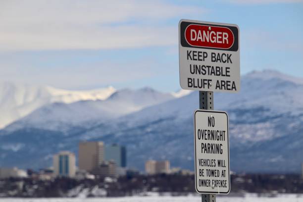 Unstable Bluff A sign overlooking a frozen Cook Inlet warns of the unstable bluff near Earthquake Park in Anchorage, Alaska. chugach mountains photos stock pictures, royalty-free photos & images