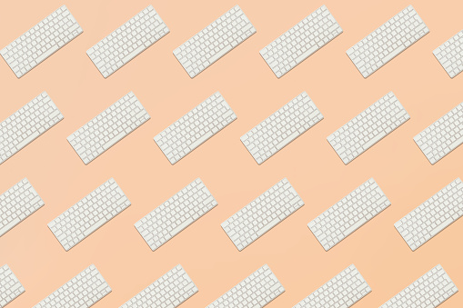 Seamless pattern from keyboard in balance on pink background