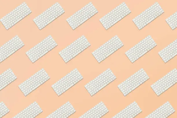 Photo of Seamless pattern from keyboard in balance on pink background