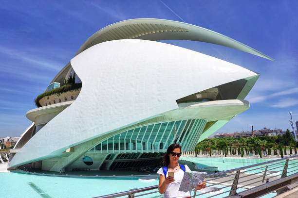 The City of Arts and Sciences in Valencia, Spain Valencia, Spain - July 26, 2017: A tourist looking at Valencia city map  and mobile phone in front of The City of Arts and Sciences.The City of Arts and Sciences is an architectural, cultural and entertainment complex in city of Valencia, Spain. parabola stock pictures, royalty-free photos & images
