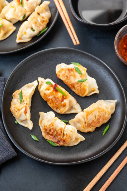 istock Jiaozi Gyoza dumplings  on black plates 1305849064