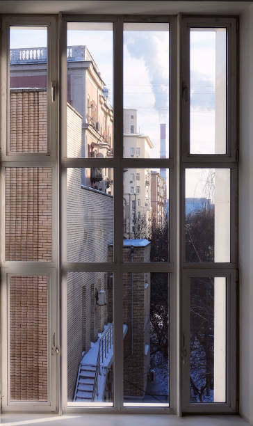 istock Window view on sunny winter Moscow streets and pipe with smoke 1305849308