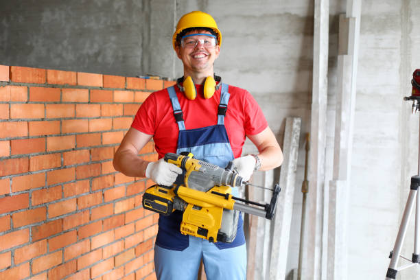 istock Smiling repairman holding in hands huge professional drill 1305850040