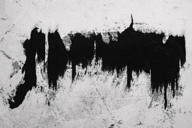 istock Scraps of black paper on a white plastered wall. 1305854839