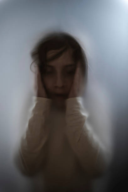 istock View of scared child through frosted glass 1305854993