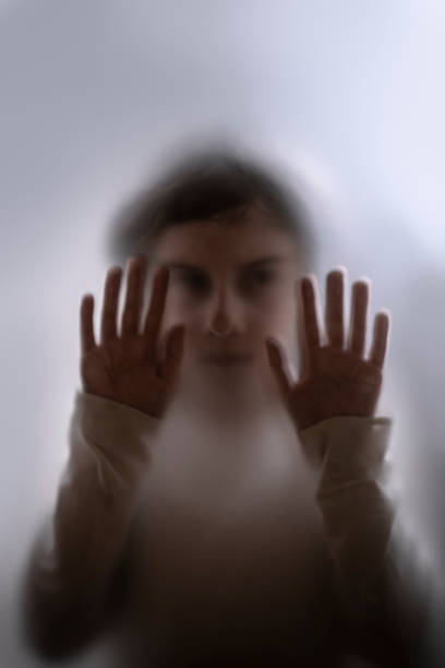 View of scared child through frosted glass