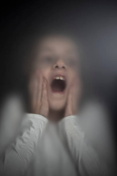 istock View of scared child through frosted glass 1305855120