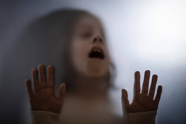 istock View of scared child through frosted glass 1305855676