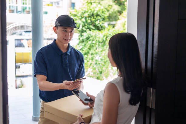 istock pizza delivery at doorstep, scanning smartphone for payment 1305856704