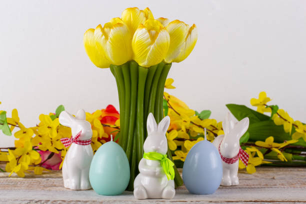 istock A tulip-shaped candle with Easter eggs, Easter bunny and a bouquet of flowers. 1305856897