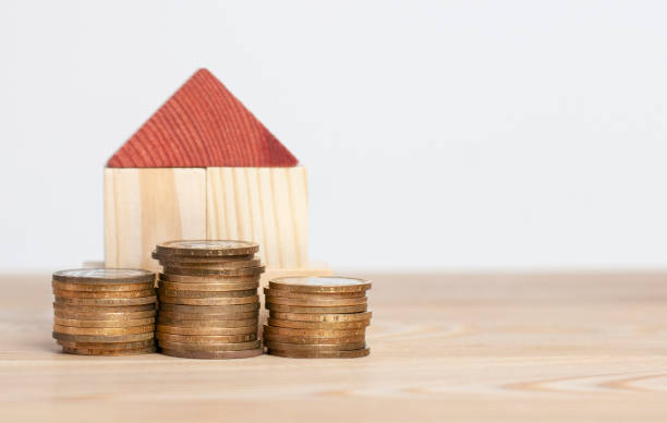 istock Wood small house with stack of coins 1305856993
