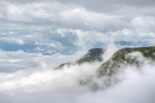 Photo of Two mountain peaks piercing through the clouds