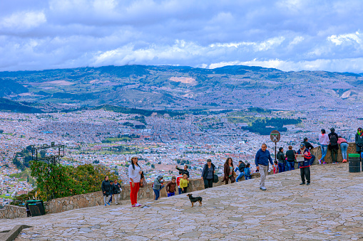 Bogotá, Colombia - June 29, 2016: A view from the top of the Andean peak of Monserrate. The distance between the plains down below is over 1,500 feet in height. The city down below is by itself over 8,500 feet above mean sea levels. Several Local Colombian people are seen enjoying the mountains. Image shot in bright sunlight.
