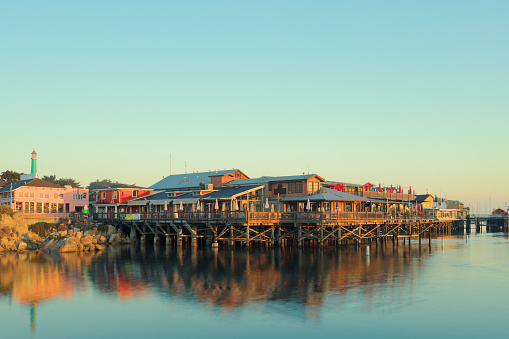 Early morning view of the Monterey Fisherman's wharf and its reflection in Monterey bay (Monterey, California).
