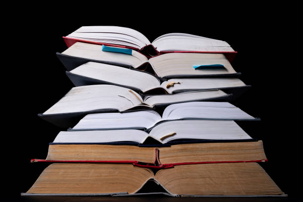 istock A stack of books on the desk. Old extensive literary publications. Dark background. 1305859444