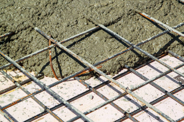 istock pouring concrete into prepared place with reinforced metal frame 1305860385