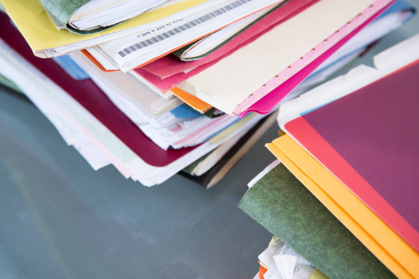 istock Stack of file folders with documents on a glass top desk. 1305861722