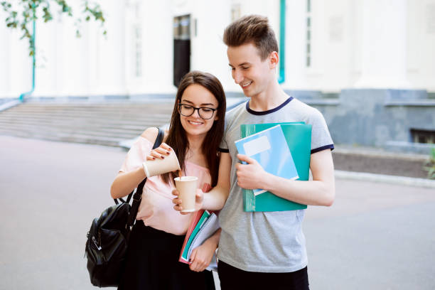 istock Two friends students near university with coffee 1305866551