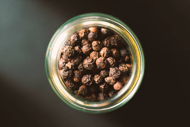 istock Black peppercorn in glass jar 1305868454