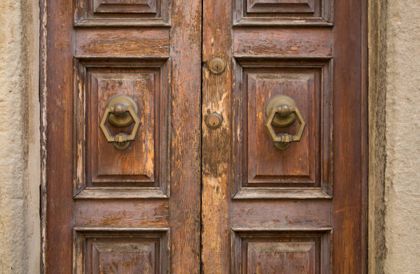 Closeup details and textures on on ancient, brown double door in Cortona, a hill town in the Tuscany region of Italy Closeup details and textures on on ancient, brown double door in Cortona, a hill town in the Tuscany region of Italy cortona stock pictures, royalty-free photos & images