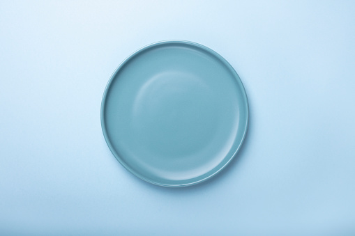 Empty blue plates on blue background with clipping Path. Top view.