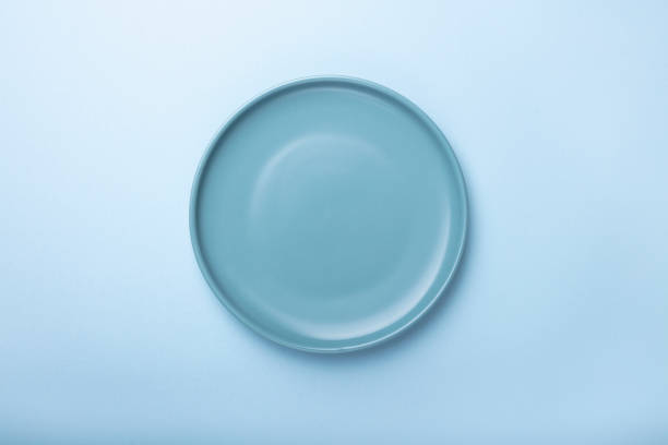 Empty blue plates on blue background with clipping Path. Top view. stock photo