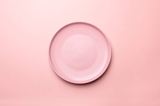 Empty pink plates on pink  background with clipping Path. Top view. stock photo