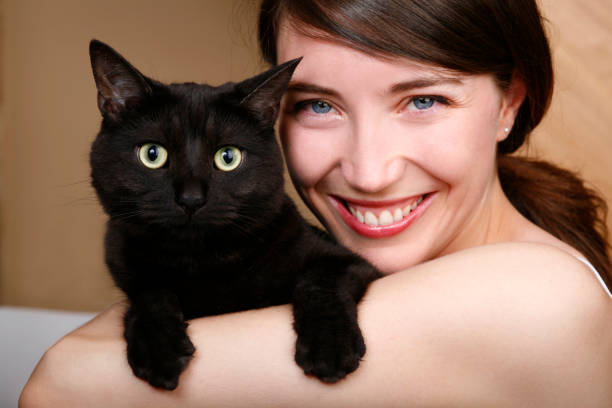 Close up of young woman with black cat.