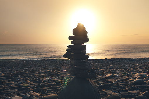 Balancing stones on idyllic beach at sunset (Crete,Greece).