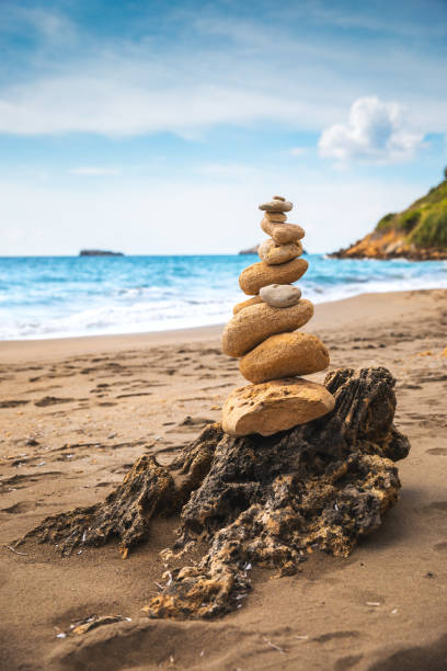 Balancing stones on idyllic Greek beach.