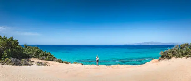Woman standing on idyllic remote wild beach on Naxos island, Greece.