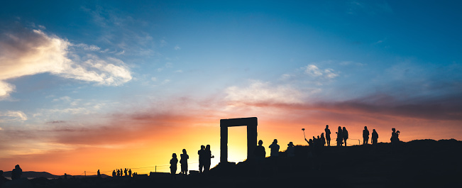 Tourists taking photos of Temple of Apollo - Portara (Naxos island, Greece).