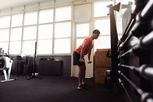 istock Young man exercising with indoor Nordic ski machine 1305883509