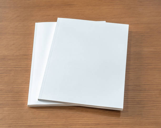 istock Book mockup with blank white front cover page a4 paperback mock up for catalog, magazine, menu, booklet, notebook, portfolio design template on wood table background 1305883578
