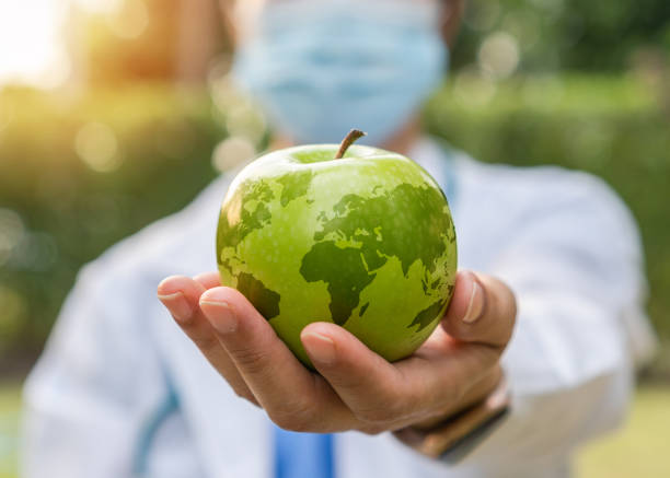 세계 보건의 날, 하루에 사과는 환자에게 녹색 사과를 주는 의사를 취급하는 의사와 함께 높은 영양가있는 깨끗한 음식과 건강한 영양 식단을 섭취함으로써 건강 상의 이점을 위한 개념을 없애� - world cuisines 뉴스 사진 이미지