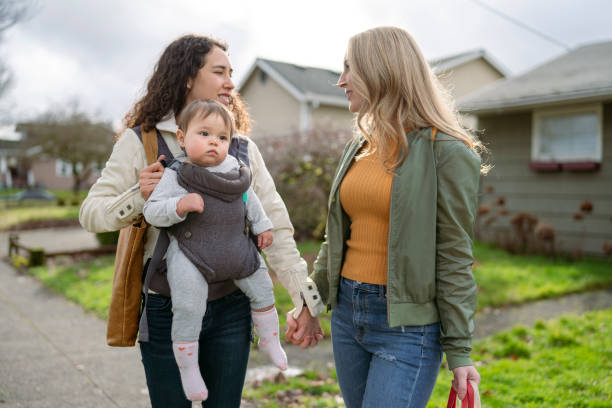 ragazza carina che guida in baby carrier mentre si gode la vita all'aria aperta con le sue mamme - alternative health care foto e immagini stock