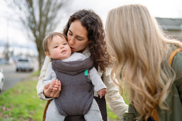 mamma amorevole che dà un bacio alla ragazza bambina carina mentre è fuori a camminare nel quartiere - alternative health care foto e immagini stock