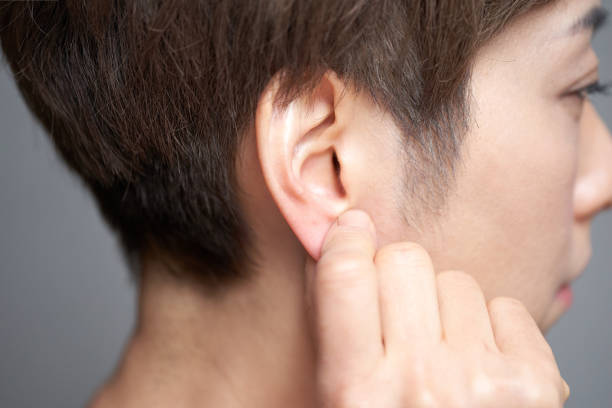 Middle-aged Japanese woman touching her earlobe Middle-aged Japanese woman touching her earlobe Earlobe stock pictures, royalty-free photos & images