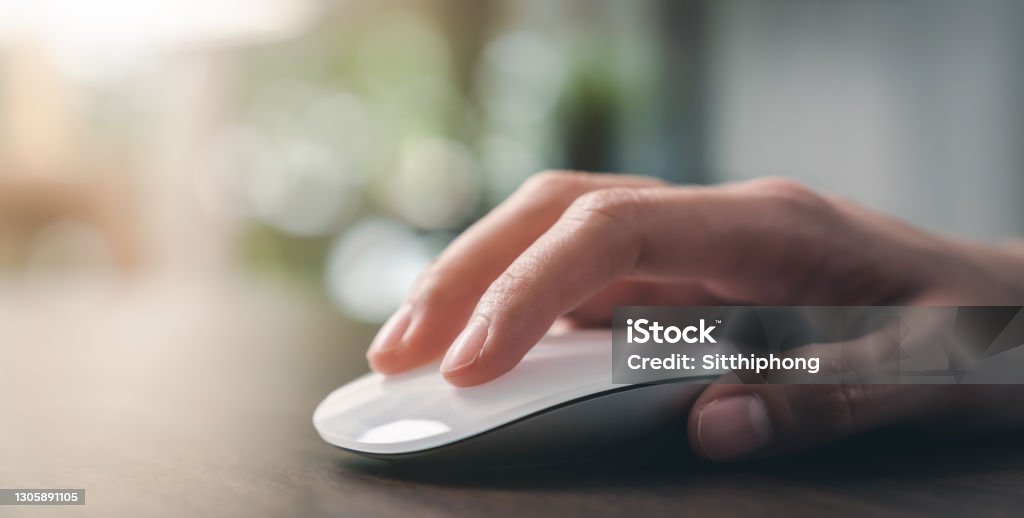 Close up of hand using on white mouse and clicking on office table. Computer Mouse Stock Photo