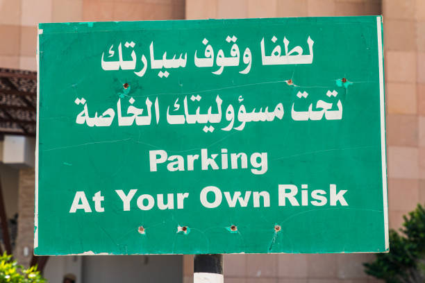 istock Parking sign in English and Arabic. 1305895320