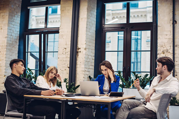istock Sad businesspeople thinking at table in office 1305901820