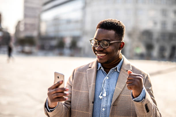 istock Cheerful young businessman using cell phone. 1305901877