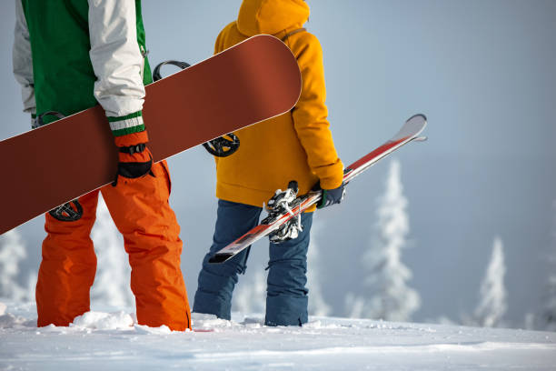 nierozpoznana para narciarzy i snowboardzistów stoi na szczycie góry - unrecognized person zdjęcia i obrazy z banku zdjęć