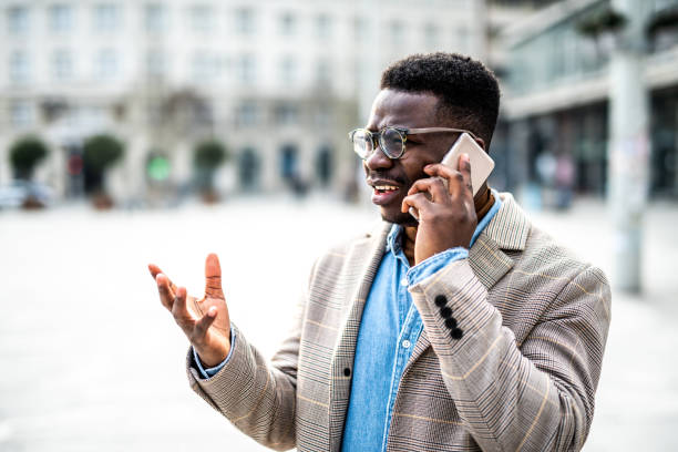 istock Frustrated young man talking on phone in the city. 1305902628